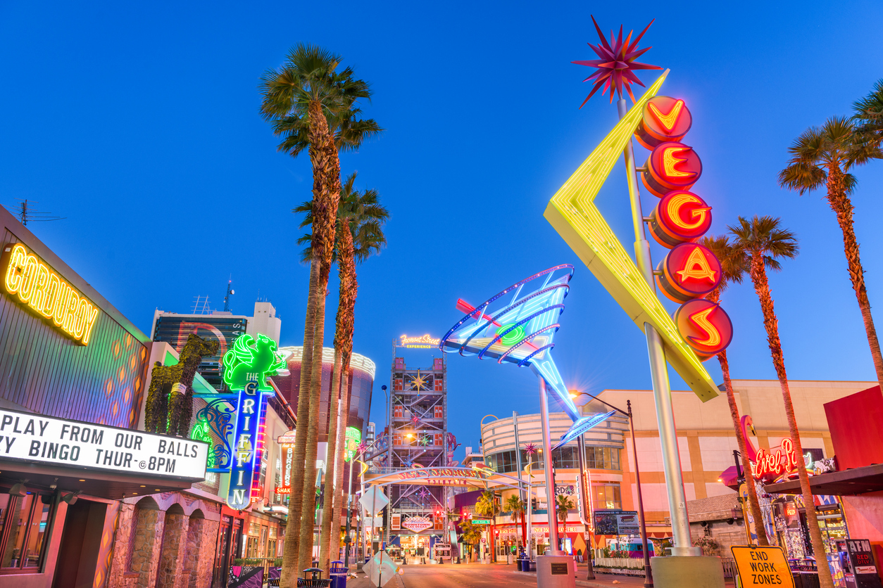 Fremont St on the Las Vegas strip is seen at night, with casinos, bars, & hotels lit up with neon lights, among them is a giant neon Vegas sign & a giant neon martini. MI joining MSIGA means BetMGM NV might be close to becoming reality.
